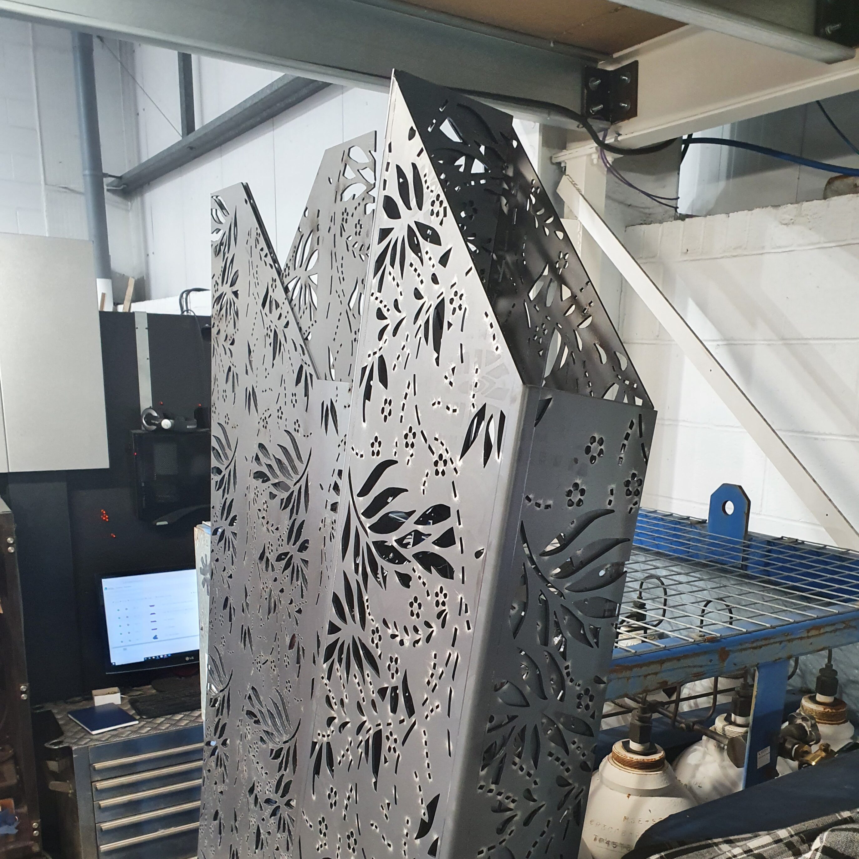 Laser cut corten steel garden goal post with decorative fretwork panels and folded sheet metal construction